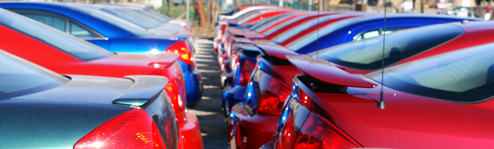 Red and blue cars parked in rows in a lot